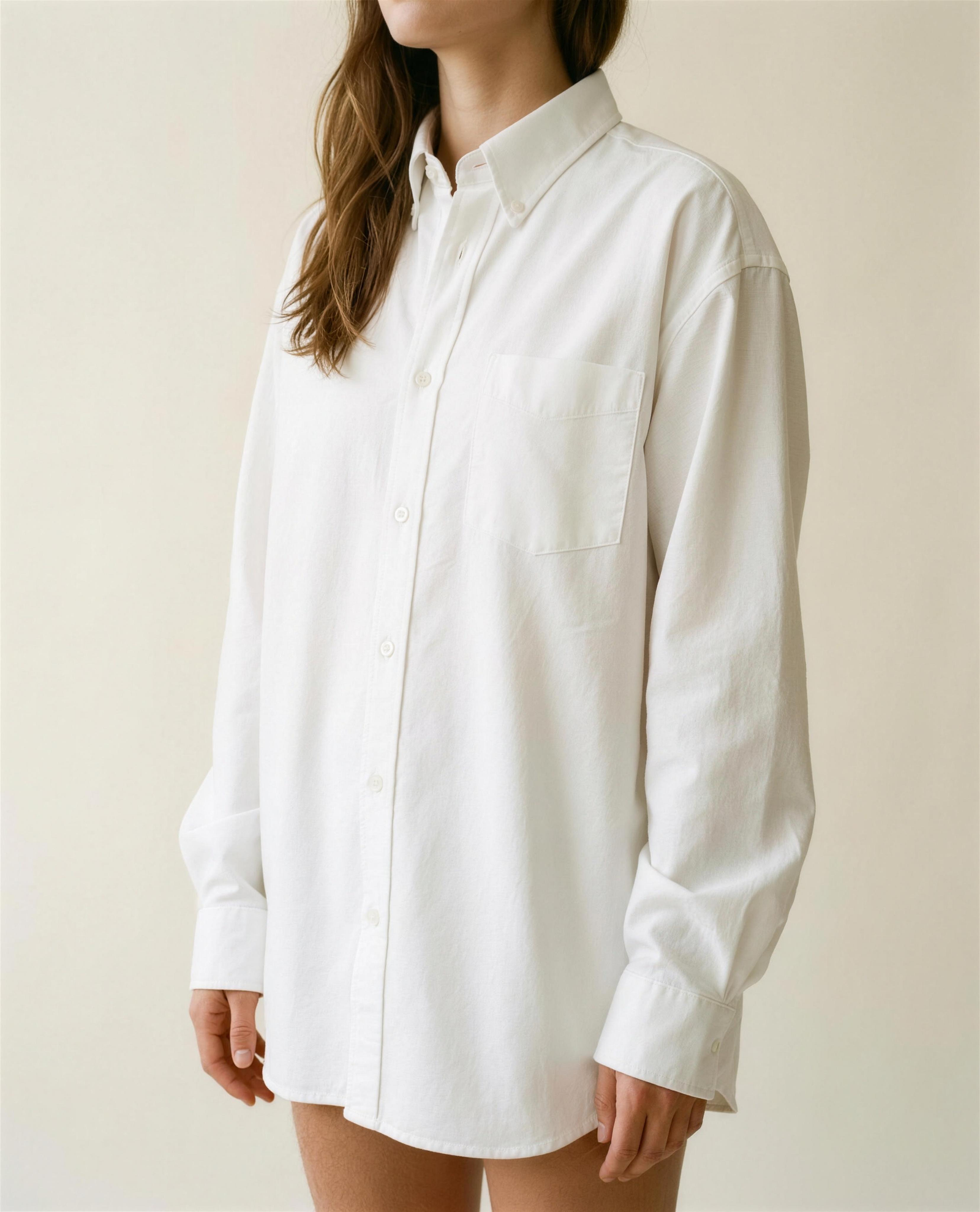 Bride wearing the white Oxford button-down oversized while getting ready, editorial studio portrait